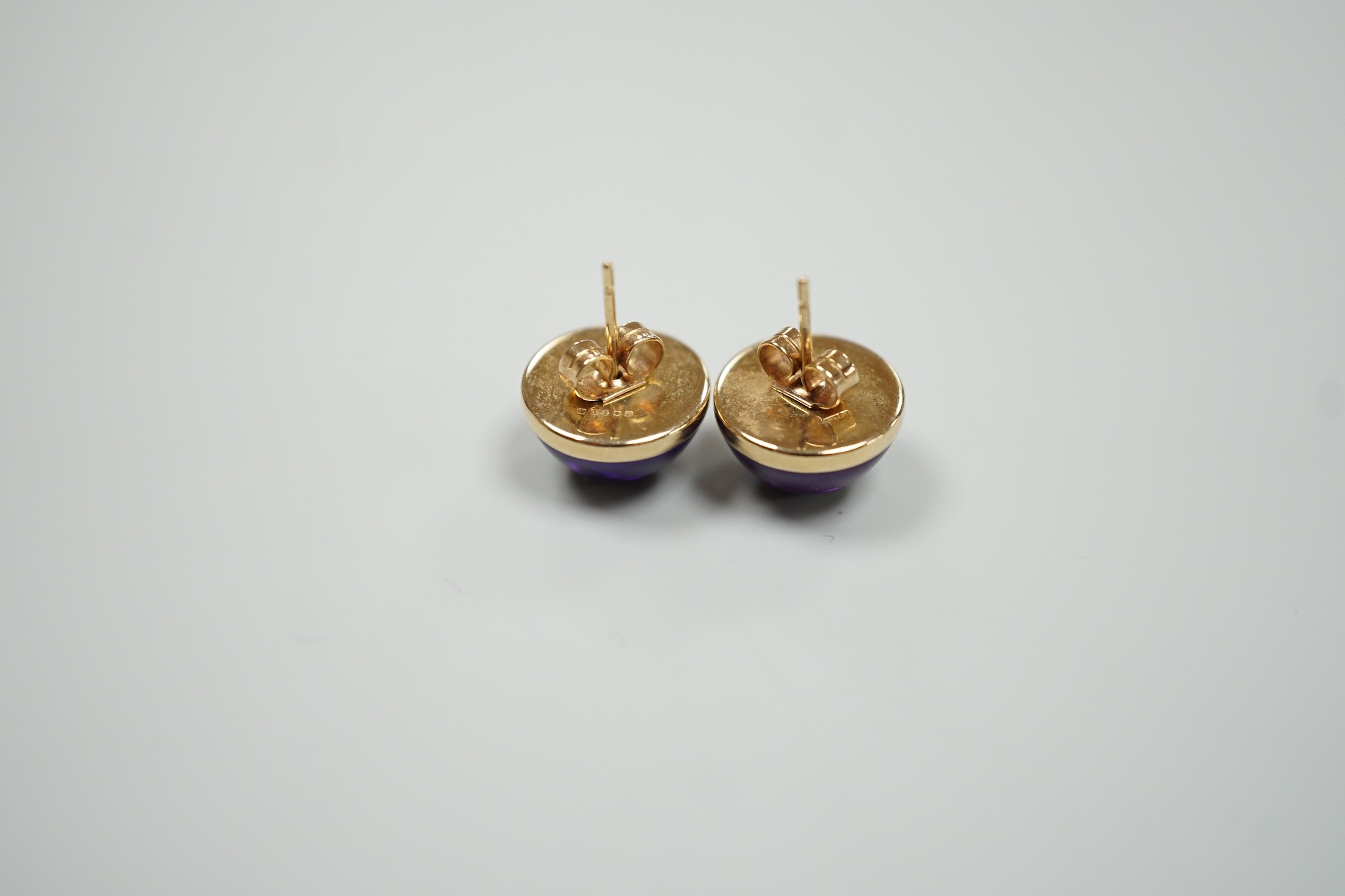 A modern pair of 9ct gold and cabochon amethyst set ear studs, diameter 14mm, gross weight 4 grams.